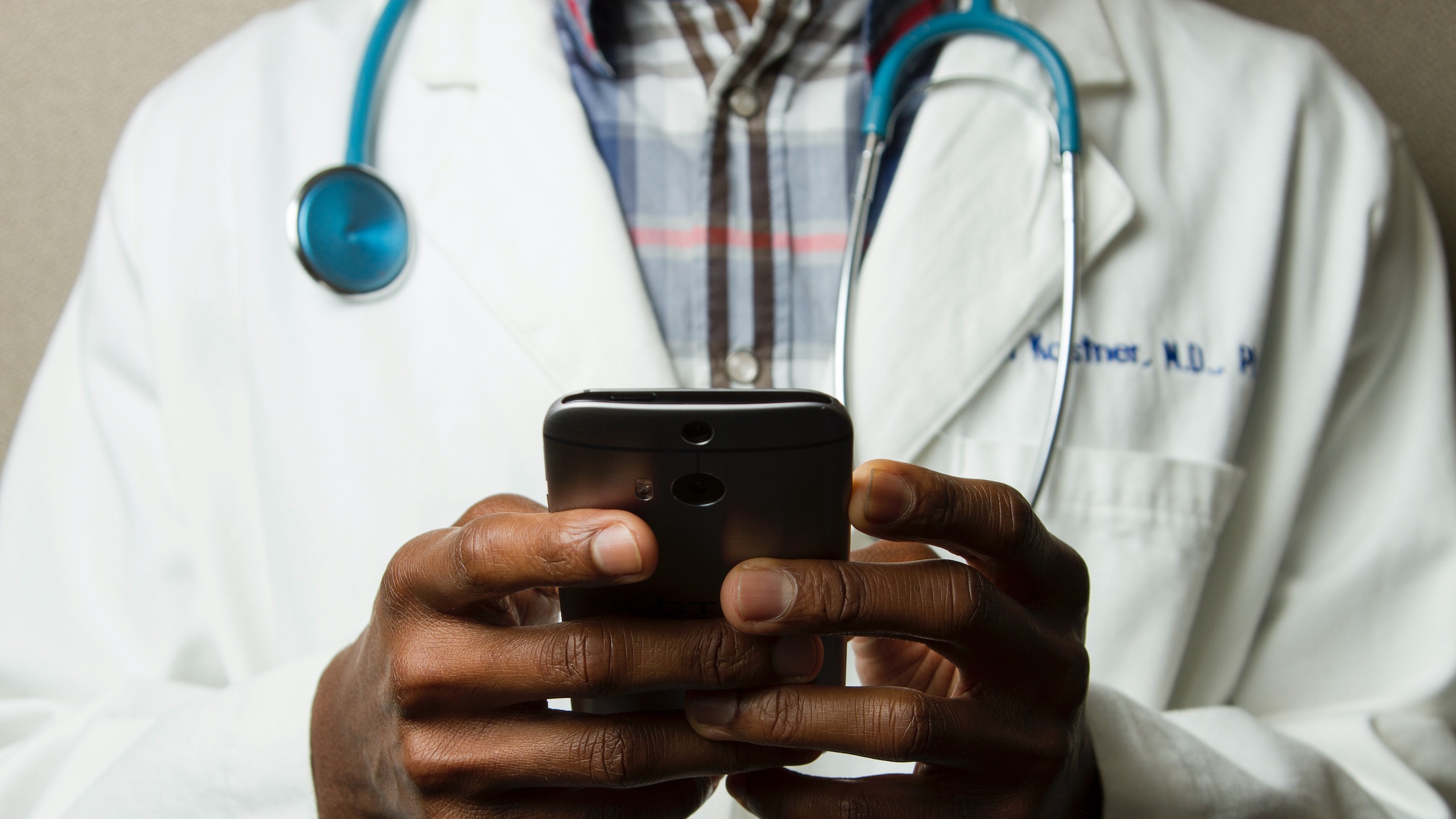 Doctor using iphone to communicate with patients as part of a modern healthcare experience